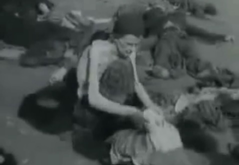 Ein
                  deutscher Kriegsgefangener oben ohne durchsucht im
                  Sommer 1945 Kleider am Boden und im Hintergrund liegt
                  ein toter, deutscher H�ftling in grauer Uniform