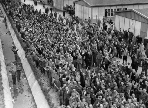 Masa de detenidos
del campo de concentración de Dachau liberada
y saludando Masa de
detenidos del campo de concentración de Dachau
liberada y saludando