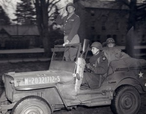 el general
              Patton en un jeep saludando sus tropas en la Normand�a,
              1944
