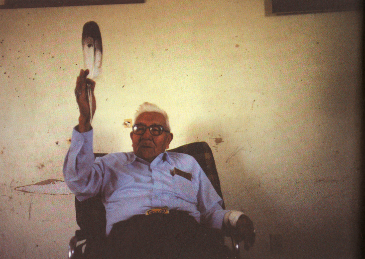 Noble Red Man (Mathew King) im Stuhl mit Feder in
der Hand, 1987 ca. Noble Red Man
(Mathew King) im Stuhl mit Feder in der Hand, 1987 ca.