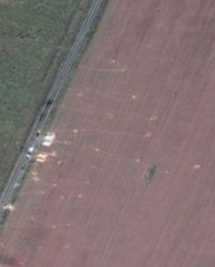 Luftaufnahme
              des benachtarten Weizenfelds mit Trampelpfaden zur
              Objektablage zur Simulation einer Explosion eines
              Flugzeugs in der Luft
