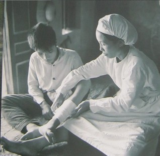Kinder im Vietnamkrieg: Eine Krankenschwester macht einen Verband: W�hrend des Kriegs waren die Schulen Ziele der "US"-Luftwaffe. Am 25. September 1965 fielen Bomben auf die Grund- und Mittelschule Quynh Tien, im Dorf Quynh Luru, Nghe An. Dabei wurden viele Sch�ler und Lehrpersonen verletzt oder get�tet.