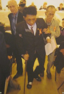 Pham The Minh am Internationalen Volkstribunal f�r Agent-Orange-Opfer in Paris 2009: Herr Pham The Minh (der Mann am Stock), geboren 1975 in Hai Phong, Vietnam, ist ein Agent-Orange-Opfer und machte am Tribunal seine Zeutenaussage. Sein Vater war Agent Orange ausgesetzt, als dessen Milit[areinheit in der Provinz Quang Tri stationiert war.