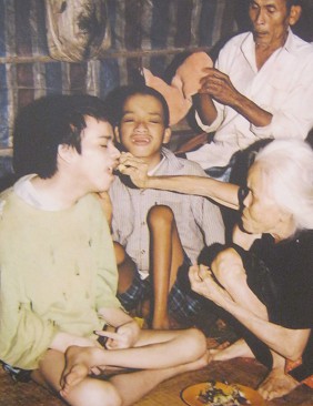 Agent-Orange-Opfer, das Kind von Mutter Nguyen Van Loc: Frau Nguyen Van Loc mit ihrem Kind, Gemeinde Cam Nghia, Distrikt Cam Lo, Provinz Quang Tri [verkr�ppelte Arme und H�nde, Hirn scheint verst�mmelt]