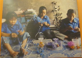 Drei Agent-Orange-Opfer machen Kunsthandwerk: Dang Thi Ngan, Ha Thi Hong Hiep, Bui Thi Nam Ky: Sie fabrizieren ein Leben lang Kunsthandwerk Dioxin-Chemie-Opfer am Zentrum "An Phuc", Stadtteil Bin Hung Hoa B, Distrikt Binh Tan, Saigon (Ho Chi Minh City). Sie machen Blumen, um Farbe ins Leben zu bringen und ihren Lebensunterhalt zu verdienen. Von links nach rechts: Dang Thi Ngan (geboren 1970), Ha Thi Hong Hiep (geboren 1975), und Bui Thi Nam Ky (geboren 1983).