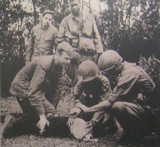 Vietnamkrieg: Die kriminelle NATO folter einen Bauern 03 mit einer Wasserfolter mit einem Lappen �ber dem Gesicht: "Sie entscheiden sich f�r eine Wasserfolter. Es wird ein Lappen �ber das Gesicht des Opfers gelegt und Wasser daraufgesch�ttet, so dass die Atmung unm�glich wird." Das sind Mitglieder der 1. Luftlandedivision, die da an einem Gefangenen eine Wasserfolter ausf�hren (ein kleines water boarding).