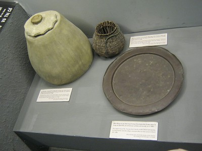Keramik aus Son My (My Lai) 01: Terra-Cotta-Reiskrug, Bambuskorb mit Fisch und Kupfertablett