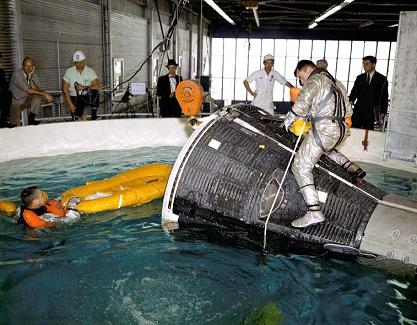 Training of the splashdown with a Mercury
                      capsule in an indoor swimming-pool ("Water
                      Tank"), foto no. S65-10157.