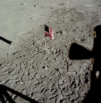 Apollo 11 Foto-Nr. AS11-37-5472:
                        Nahaufnahme des "Mondbodens" mit
                        Fahne, Kamerakabel und mit dem Schatten des
                        Solarwindkollektors