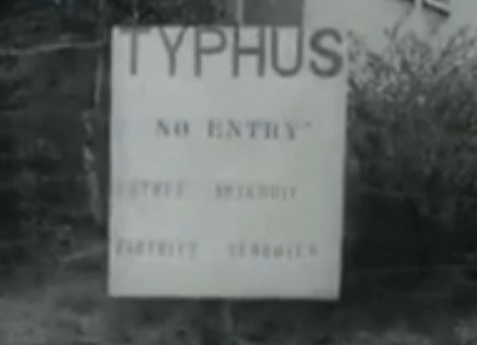 Tafel mit der Behauptung "Typhus" im
                Konzentrationslager Bergen-Belsen auf Englisch