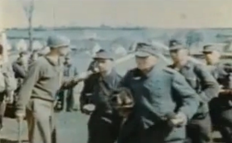 "American" guards are dividing the
                  Germans before an entrance gate of a Rhine meadow
                  camp