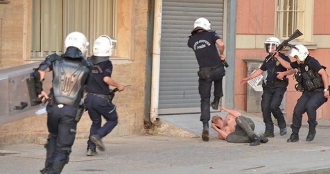 Trkische Schlgerpolizei 31, drei
                          Marsmenschen bekmpfen einen Demonstrant ohne
                          Hemd, der bereits am Boden liegt