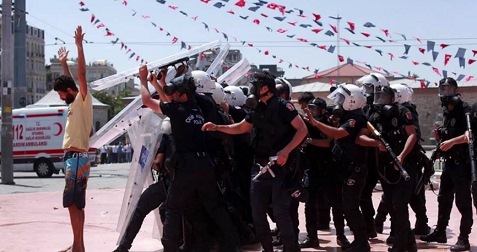 Trkische Schlgerpolizei 40, ein
                          Demonstrant im Hemd wird von einer Menge
                          bewaffneter Marsmenschen mit
                          Plexiglasschildern angegriffen