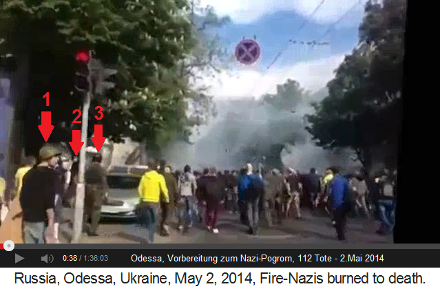 Pogrom in Odessa, Taktschl�ger haut mit
                    einem Pflasterstein gegen einen Laternenpfosten,
                    Milit�rpolizist und Schl�ger mit Helm sind neben
                    ihm