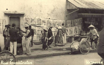 Die Hafenstadt Haiphong in Nordvietnam,
                    Tonkingstrasse mit Zeitungen+Rikscha 1920 ca.